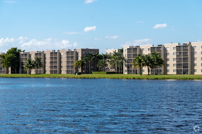 View across the water at Lakeshore Apartments, a serene lake on a beautiful day.