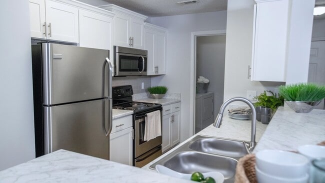 Carrara marble-inspired countertops grace the breakfast bar, creating a timeless and luxurious atmosphere in this expansive kitchen. Ample countertop space and storage ensure both style and functionality.