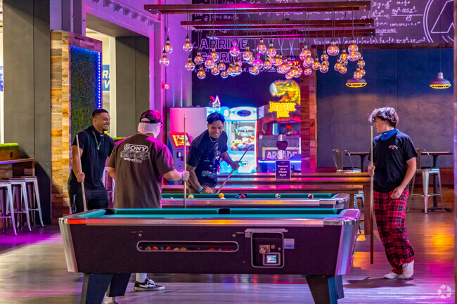 Friends play a game of pool at K1 Speed Indoor Kart Racing in Barrio Logan.