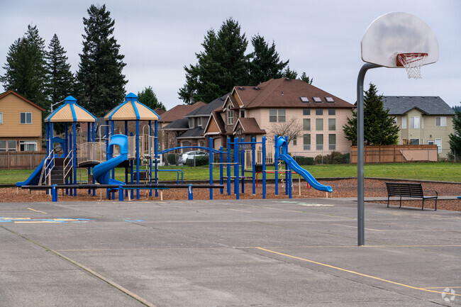 The playground structure features slides and monkey bars.