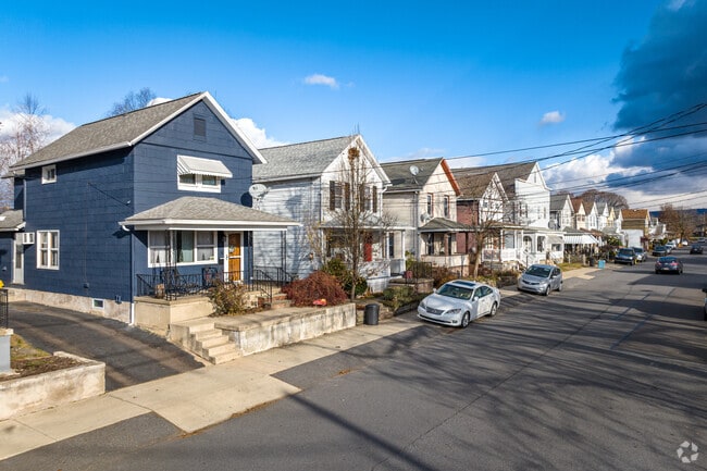 A row of shotgun-style homes fades into the distance down a residential street in Exeter, PA.