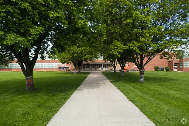 The front walkway of Goodrell Middle School is shaded by large trees invites students inside.