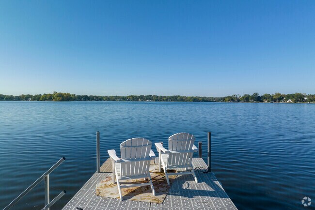 Two Adirondack chairs frame the perfect scene to end your day on the banks of Long Lake.