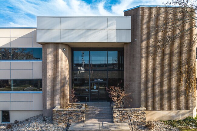 A mature tree sits on a lawn in front of Salt Lake Virtual School.