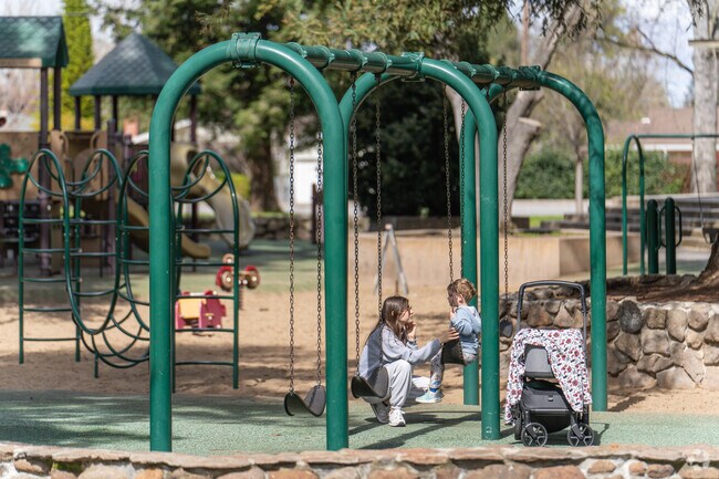 A young mother and son enjoy a moment together on the swings at Cuesta Park.
