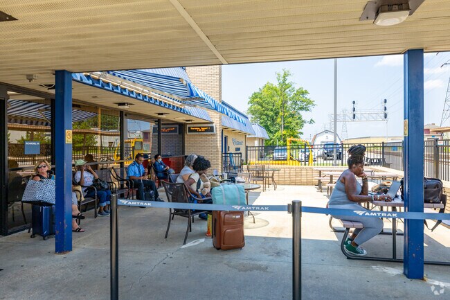 Travelers relax on the patio at Dumbarton’s Amtrak station while waiting for their train.