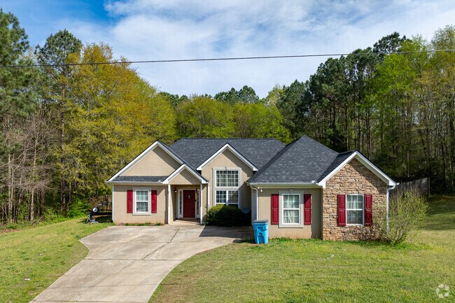This warm and inviting ranch-style home is tucked into the wooded tranquility of Towaliga Shores, blending Southern charm with practical design in a nature-rich setting.