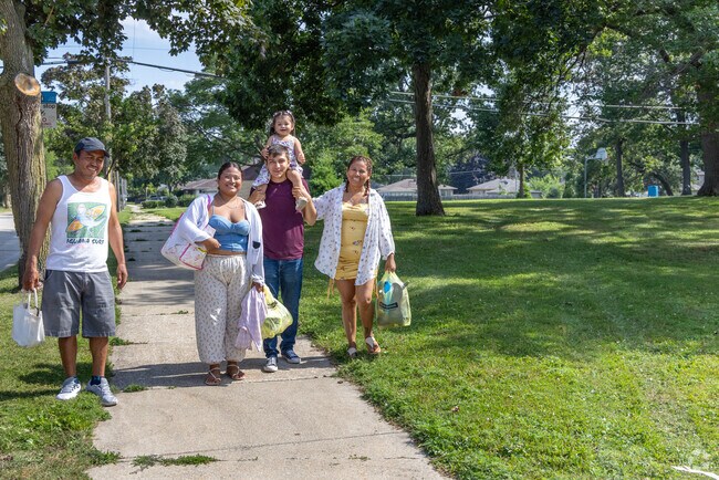 A happy family passes through Greencrest Park on a beautiful summer day.