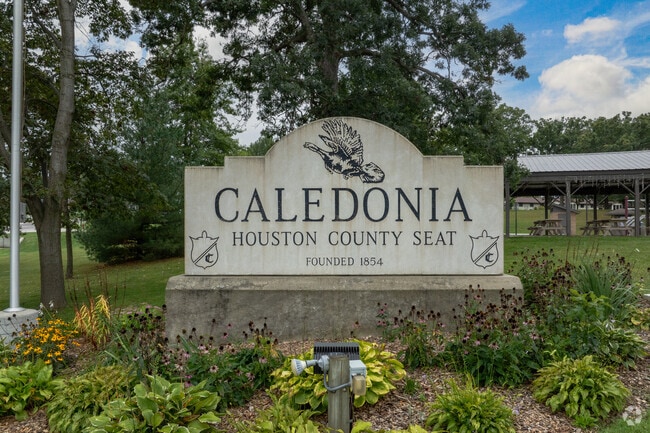 Seasonal flowers surround Caledonia’s welcome signage near the town center.