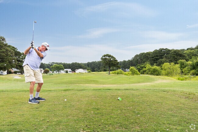 Golfers tee off on Captain's Cove Golf Course, the community's lush 9‑hole gem in Greenbackville.