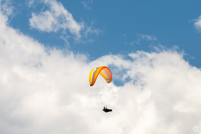 Paragliders fly above Foothills Community Park making their way down to the large open field.