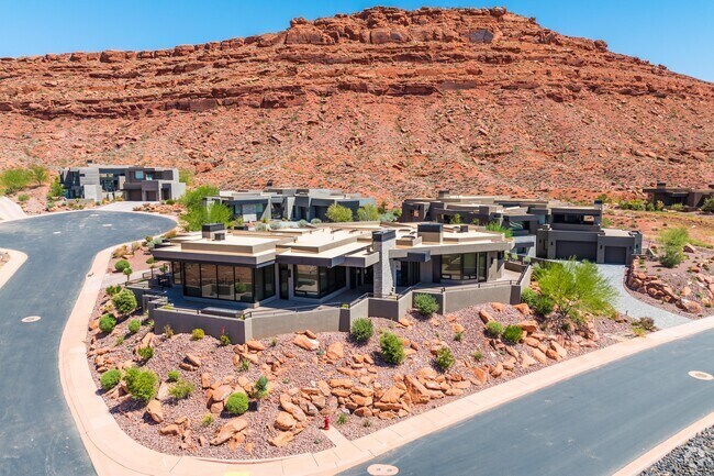 The single family houses have great views of the red cliffs around them.