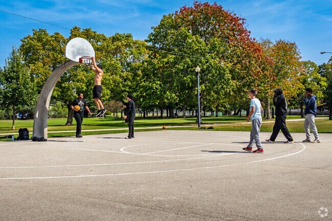 Joannes Park playscape sits in the shade of large, mature trees in Green Bay, WI.