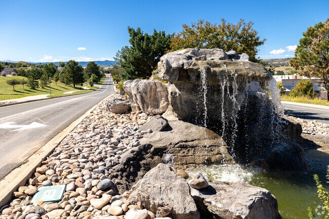 Plum Creek neighborhood showcases a rocky fountain amid its scenic charm.