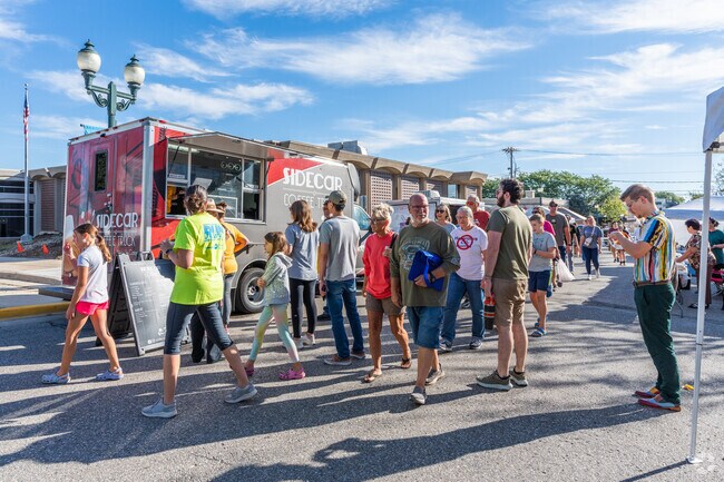 The Cedar Falls Farmers Market is crowded with visitors looking to buy trinkets.