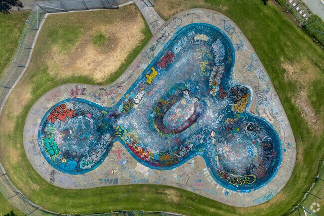 Every inch of the bowl at Greer Park Skatepark is covered in teal and colorful graffiti.