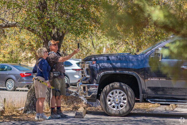 A couple poses for a selfie near a trailhead in Madera Canyon, capturing the moment before heading out on one of the area's scenic forest hikes in Green Valley.