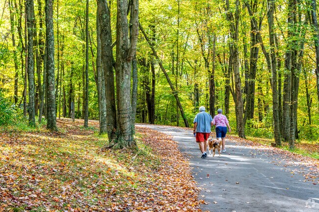 A couple walks their dog on the scenic trails of Clinton Community Park.