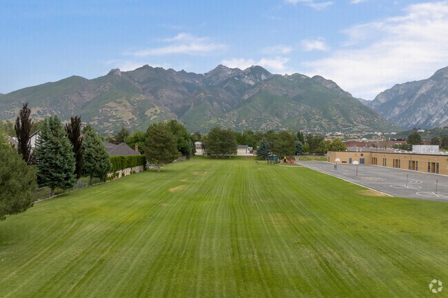 A sprawling green lawn with a view of the Wasatch Mountains at Quail Hollow Elementary School.