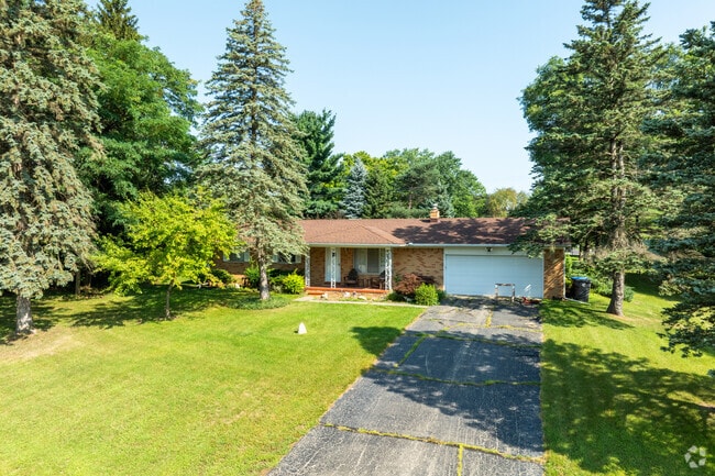 A charming ranch-style home is tucked beneath mature trees, offering peaceful seclusion, shade, and natural privacy year-round.