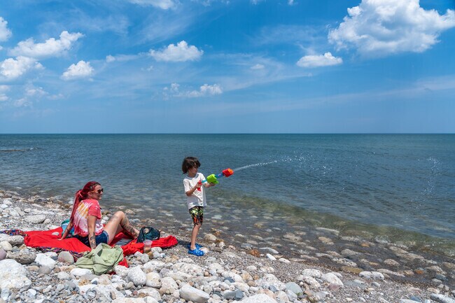 A mom watches her son spray water into Lake Michigan at Alford Park.