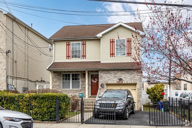 West Side home features a brick and siding exterior, a gated driveway, and a welcoming front porch.