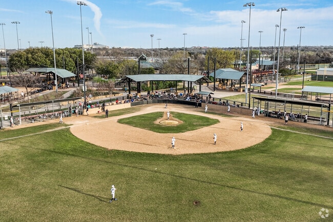 Grapevine locals watch and play baseball at Oak Grove Park.
