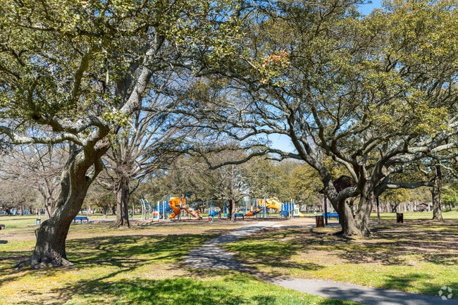 Families enjoy leafy parks in Lafayette-Winona while children climb and swing nearby.