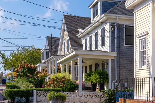 Rows of Cape Cod homes feature porches and manicured gardens in Provincetown.