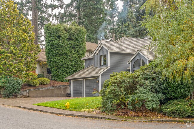 A row of northwestern split-level homes tucked behind evergreens in Marylhurst.