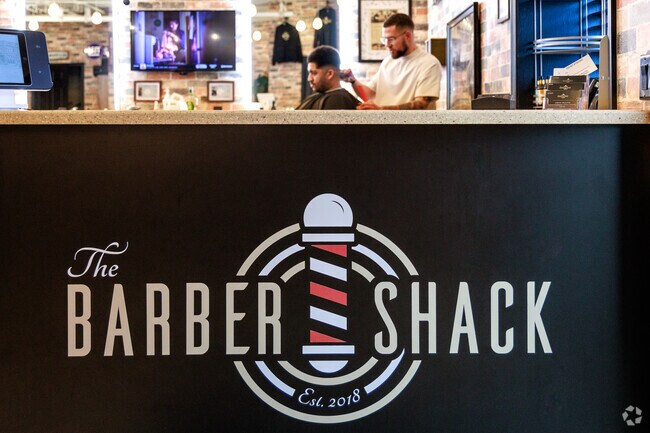 A man gets a trim behind the sign at The Barber Shack in Camillus, NY.