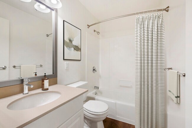 Renovated Package III bath with grey quartz countertops, white or cherry cabinetry, and hard surface flooring