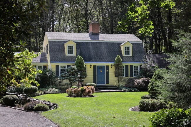 Sun baths a home with warmth amongst the neighboring woods.