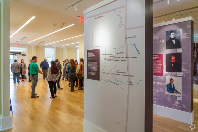 The interior of the museum in Tahlequah is filled with visitors exploring exhibits, creating a lively atmosphere.