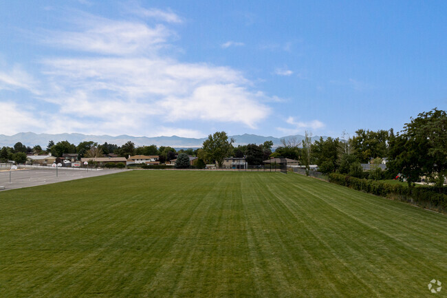 A large grassy field with a view of the mountains at Peruvian Park Elementary.