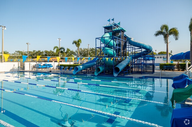 Swimmers lap at the Fort Myers Aquatic Center near Palm Lee Park as kids use waterslides.