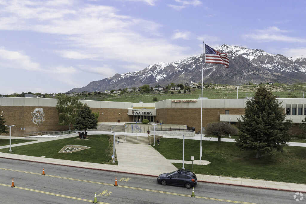 A front view of Weber High School with a flag waving in the wind in Pleasant View.