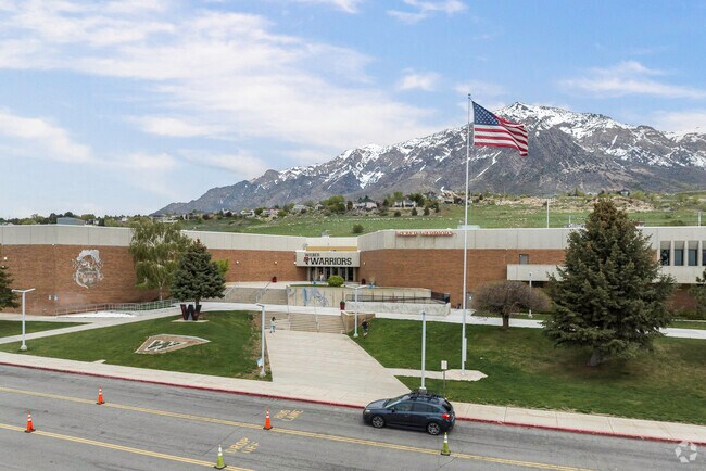 A front view of Weber High School with a flag waving in the wind in Pleasant View.