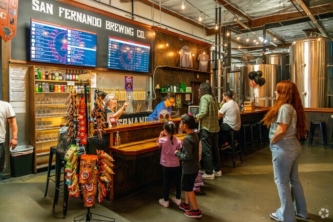 Inside San Fernando Brewing Co, locals chat and order drinks, adding to the lively atmosphere of the city’s craft beer scene.