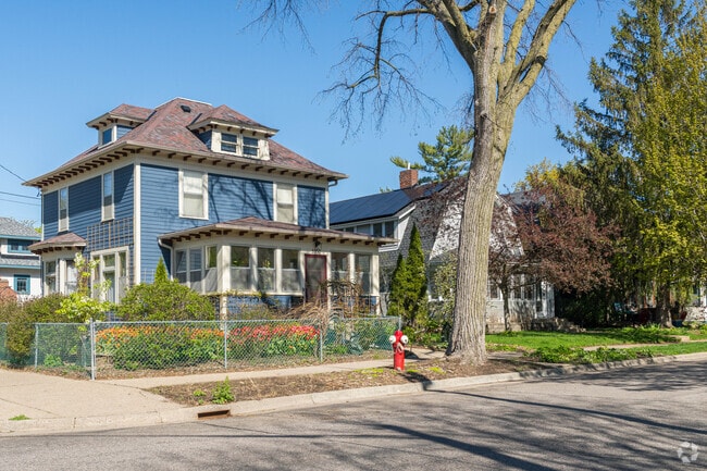 A foursquare style home in South Uptown with a bed of blooming tulips.