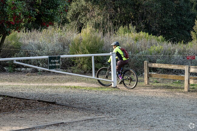 A biker riding onto the trail from the parking lot at Powder Canyon trail in  La Habra Heights.
