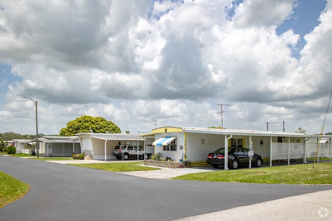 Manufactured homes with carports and awnings line quiet streets in Zephyrhills West.