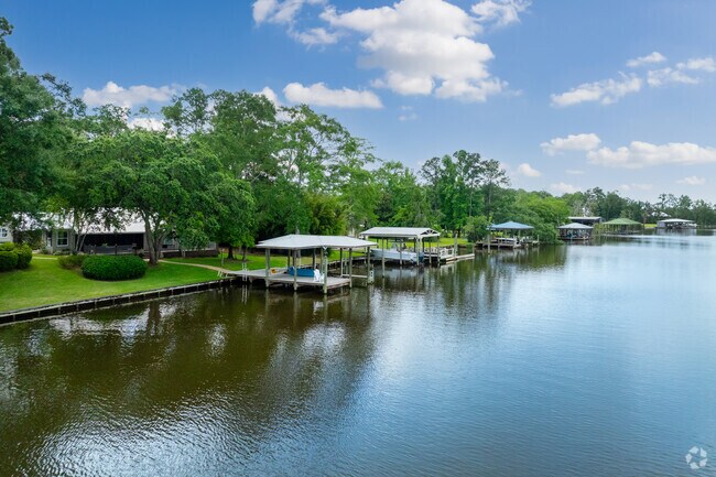 Homes on the river in Cypress Shores have covered docks for their boats.