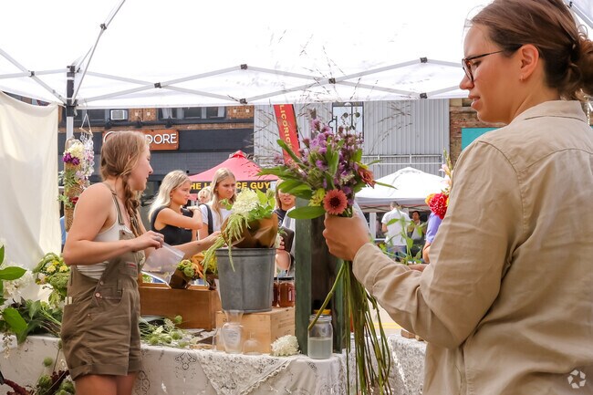 Local residents browse beautiful blooms from flower vendors at Appleton Farm Market.