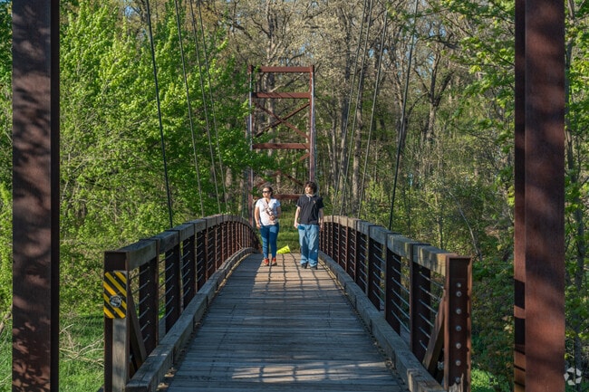 A mother and son walk over the Big Rock Forest Preserve Footbridge.