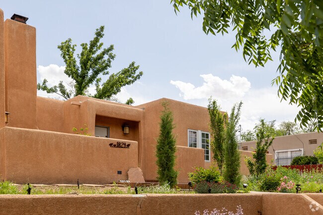 This Pueblo Revival home features earth-toned stucco and a peaceful front patio in Silver Hill.