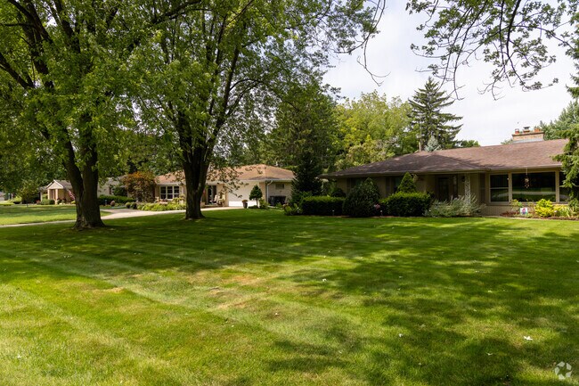 Tall trees and green lawns sit along the the streets.