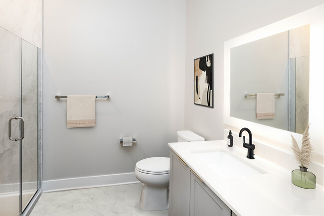 Signature Collection bath with white quartz countertop, grey cabinetry, and marble quartz bath surround (Representative photo)