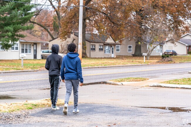 Two young men walk down the sidewalk after making a visit to the strip mall in Spanish Lake.