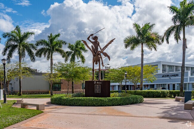 Don Quijote Plaza offers shaded sitting areas around a large bronze statue.